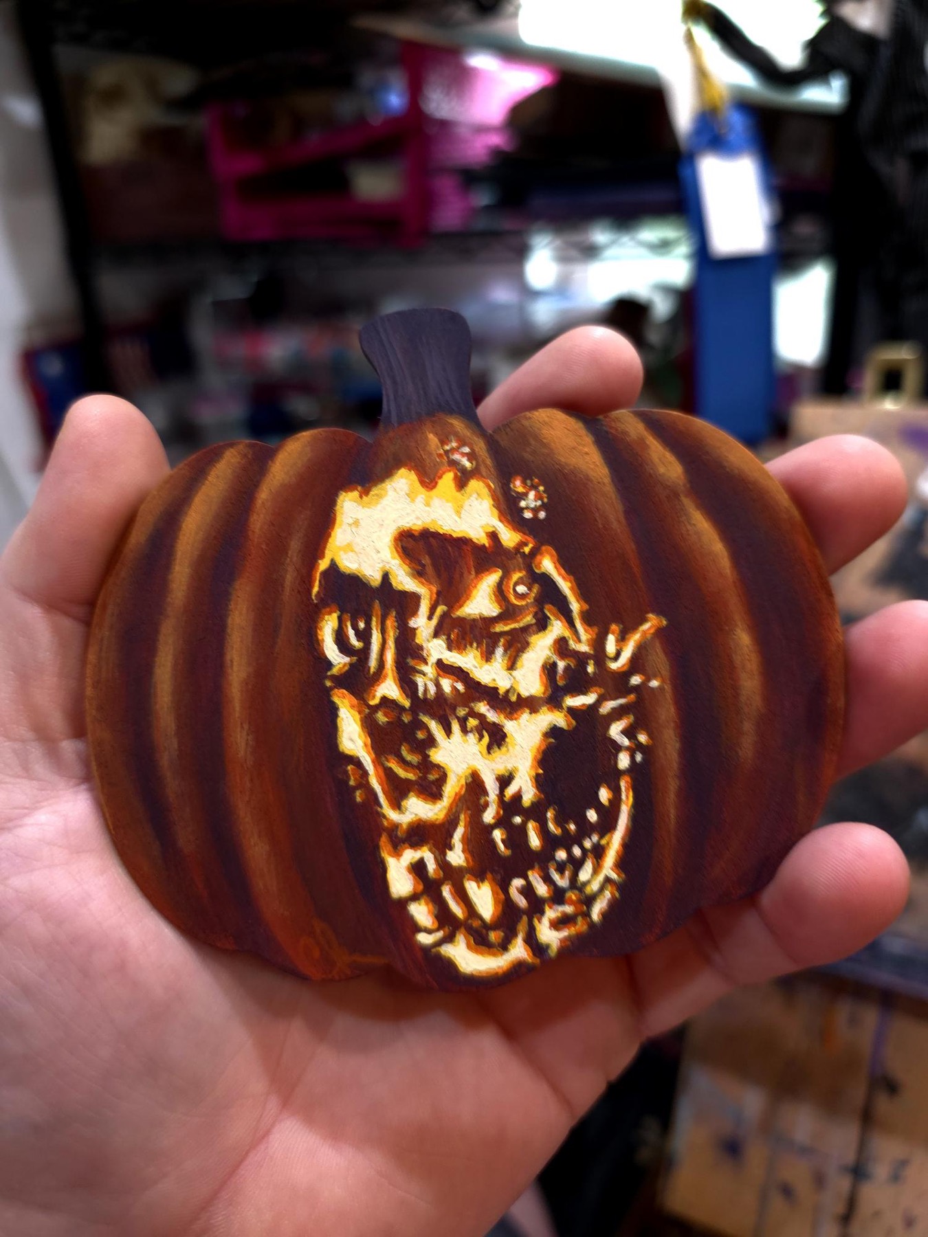 Small carved pumpkin with glowing skull monster face